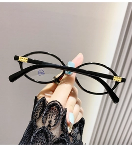 Gros plan de lunettes rondes rétro noires avec charnières dorées et verres anti-lumière bleue