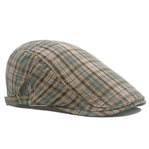Détail de la boucle en cuivre ajustable et texture à carreaux vintage du béret plat
