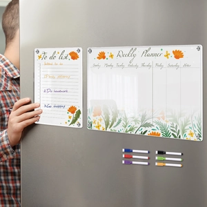 Close-up of magnetic acrylic weekly planner and to-do list on a stainless steel fridge