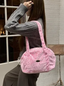 Détail du sac bandoulière en peluche à motif léopard rose avec logo métallique