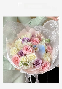 Close-up of pink roses with white lace mesh packaging and delicate pearl chain detail
