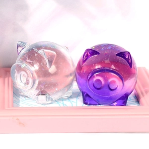 Detailed view of DIY resin pig ornaments with glitter sequins in pink and purple colors