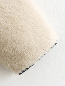 Detailed macro texture of soft cream faux shearling fleece fabric for stylish outerwear