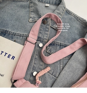 Close-up of pink corduroy dumpling bag featuring adjustable strap and smooth zipper detail