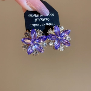 Close-up of 925 silver stud earrings with purple marquise crystals in a floral design