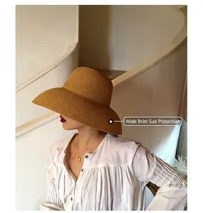 Detail of caramel wide brim straw hat showing woven texture and sun protection features