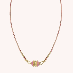 Detail of pink enamel drum pendant with green stone on a red braided gold thread cord