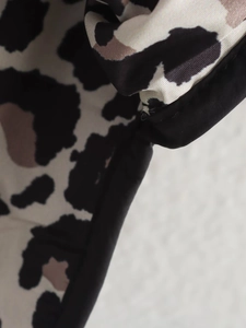 Detailed view of the leopard print fabric with black trim and stitched edge finish