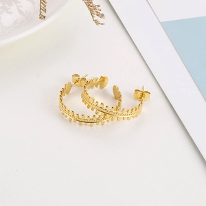 Detail shot of golden C-shaped hoop earrings with unique fishbone texture design