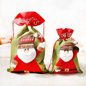 Festive red and green Christmas gift bags with plush Santa Claus decorations