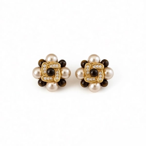 Boucles d'oreilles fleurs vintage plaquées or avec perles et zircons sur fond blanc