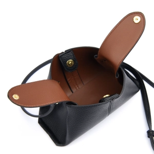 Detail of black leather mini bucket bag showing brown lining and gold magnetic closure