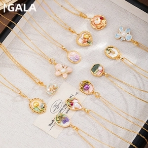 Detail of vintage enamel pendants with pearls and floral designs in a display box
