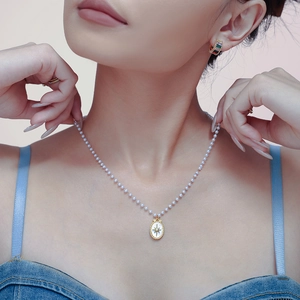 Elegante collana di perle con ciondolo a stella in madreperla dorata su una modella