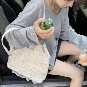 Gros plan sur la texture en dentelle beige d'un grand sac à bandoulière pour femme