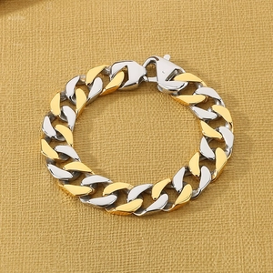 Detailed macro view of two-tone gold and silver Cuban link bracelet with lobster clasp