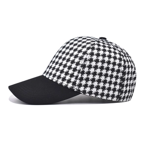 Detailed side view of houndstooth plaid baseball cap with black curved brim and vintage style