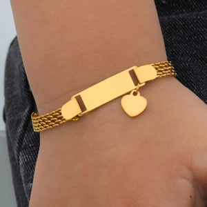 Detail of golden mesh bracelet with blank engravable plate and heart charm pendant