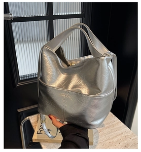Detail shot of silver tote bag with crinkled metallic texture and stylish soft handle