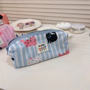 Détail de la trousse en toile à rayures bleues avec imprimé chat et fermeture éclair