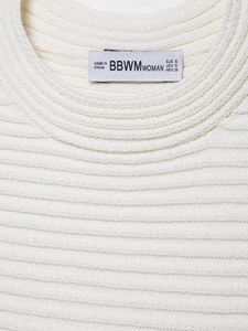 Close-up of white ribbed knit top showing neckline detail and size S brand label