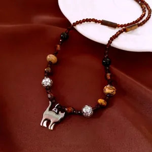 Vintage beaded necklace with brown glass stones and a small silver cat pendant