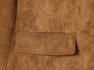 Close-up of caramel suede blazer featuring a classic flap pocket and fine texture