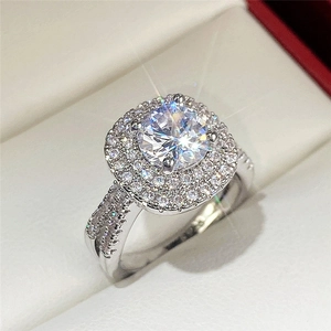 Macro shot of silver-tone ring with brilliant round center stone and double halo pave setting
