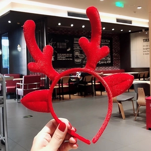 Festive red plush reindeer antler headband with glitter accents for Christmas party