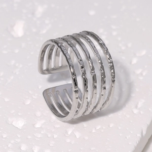 Macro shot of silver multi-layer open ring with hammered texture on white stone base