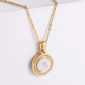 Gold round pendant necklace with letter A and white crystal rhinestones on a white background