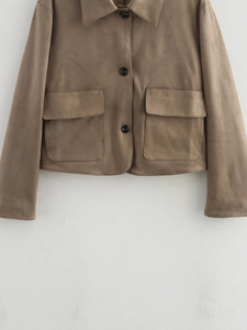 Detailed close-up of brown suede jacket showing classic lapels and front flap pockets