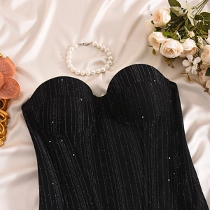 Flat lay detail of black glitter corset top with boning on silk with pearl accents
