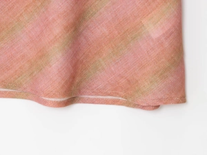 Close-up of peach and green striped linen midi skirt showing hemline stitching details