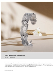 Detailed view of silver titanium steel feather bangle with vintage textured carving