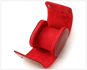 Detail view of a portable leather watch case with premium red velvet lining and snap closure
