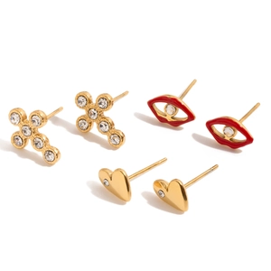 Trois paires de boucles d'oreilles en acier avec motifs cœur, lèvres et croix