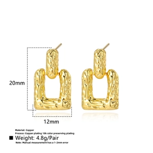 Detail showing 18k gold plated rectangle earrings with unique hammered texture surface