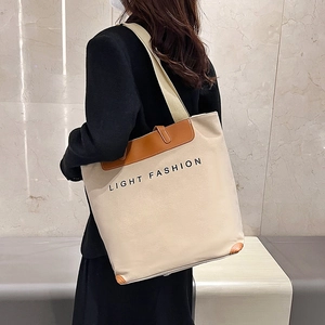 Minimalist beige canvas tote bag with brown leather trim and Light Fashion text print