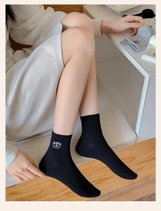 Detail of cartoon bear embroidery on black cotton crew socks with soft ribbed cuffs