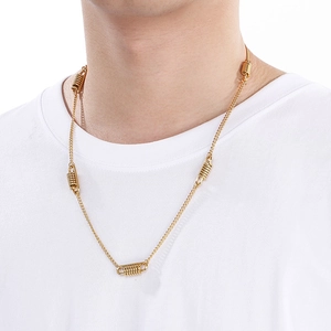 Detail of gold spring-style pendants on a stainless steel cuban link necklace