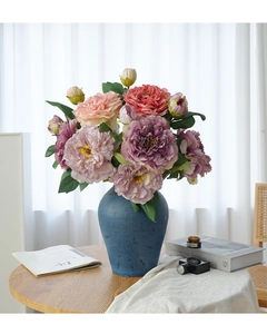 Pink and champagne silk peonies in a blue ceramic vase on a wooden table setup