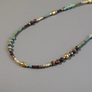 Bohemian handmade beaded necklace with turquoise, wood, and gold accents in French style