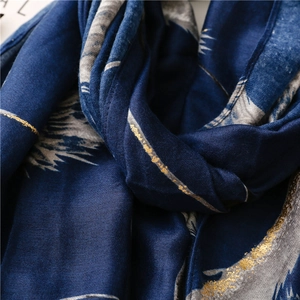 Detailed macro view of soft navy cotton-linen scarf with golden feather foil print