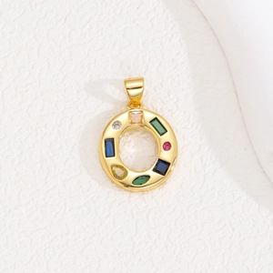 Close-up of golden round pendant with colorful cubic zirconia and vibrant gemstone inlay
