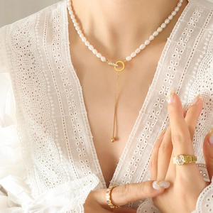 Freshwater pearl necklace with gold double rings and tassels on white lace top
