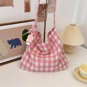 Detailed texture of pink and white checkered canvas tote bag with floral cloud charms