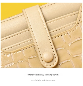 Detail of cream short wallet featuring crocodile pattern embossing and fine stitching