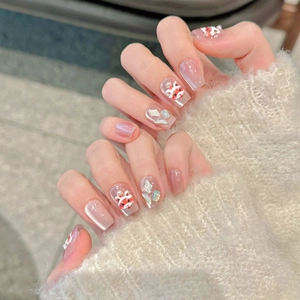 Pink cat-eye press-on nails with 3D lion dance relief and pearls in warm lifestyle setting