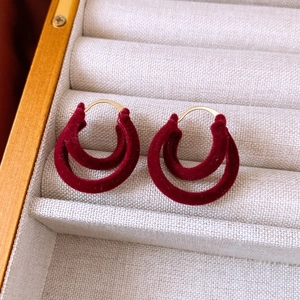 Detailed close-up of double-hoop earrings featuring burgundy velvet flocking and metal frame